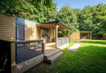 Vista exterior de la Lodge at Urban-Gardens Ieper en Bélgica, cabaña moderna de madera con terraza techada.