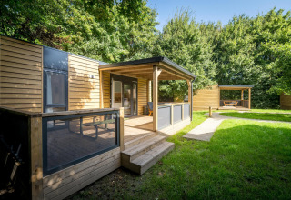 Vista esterna della Lodge at Urban-Gardens Ieper in Belgio, moderna cabina in legno con patio coperto.