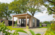 Panorama lodge med wellness og jacuzzi på Vakantiepark Hölte, omringet af træer i Holland.