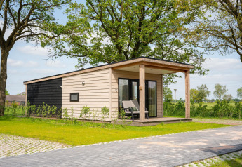 Panorama lodge met wellness en jacuzzi in Vakantiepark Hölte, modern tiny house te midden van het Nederlandse groen.
