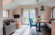 Lichte, moderne lodge woonkamer en eetruimte met grote ramen bij Vakantiepark Leukermeer, Nederland.