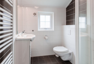 Bagno moderno al Lodge nel Vakantiepark Leukermeer, Olanda, con finestra e wc sospeso a parete.