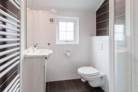 Bagno moderno al Lodge nel Vakantiepark Leukermeer, Olanda, con finestra e wc sospeso a parete.