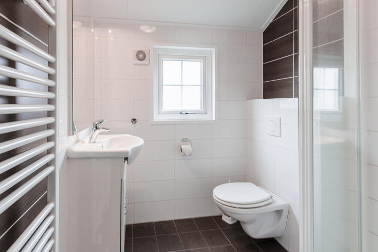 Modernes Badezimmer in der Lodge im Vakantiepark Leukermeer, Niederlande, mit Fenster und Hänge-WC.