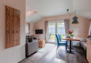 Sala luminosa de la cabaña con muebles modernos y mesa de comedor en Lodge en Vakantiepark Leukermeer, Países Bajos.