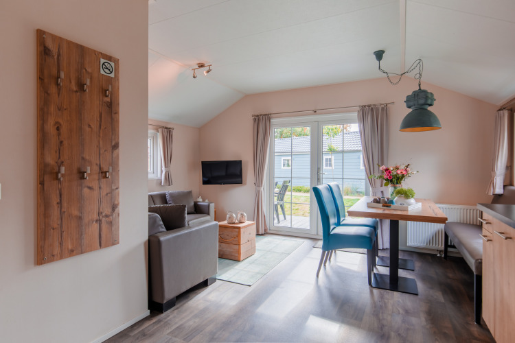 Helles Lodge-Wohnzimmer mit modernen Möbeln und Esstisch in der Lodge im Vakantiepark Leukermeer, Niederlande.