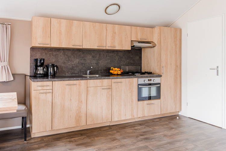 Moderne Holzküche in der Lodge im Vakantiepark Leukermeer, Niederlande, mit Geräten und Backofen.