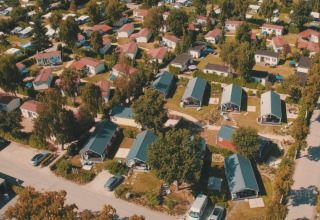 Vista aérea de cabañas y vegetación en Lodge en Vakantiepark Leukermeer, Países Bajos, en temporada de verano.