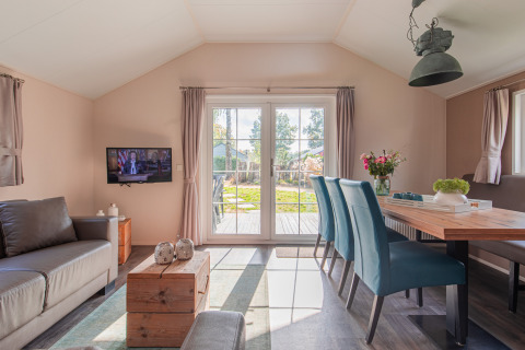 Bright interior of a lodge at Vakantiepark Leukermeer with modern furnishings and garden view.