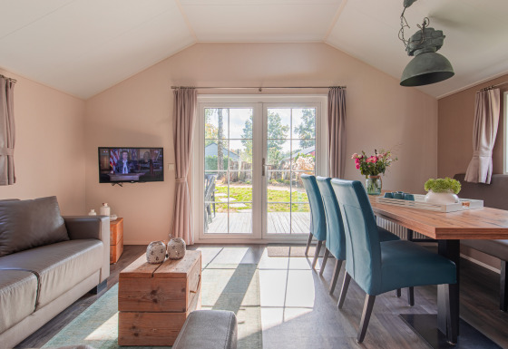 Bright interior of a lodge at Vakantiepark Leukermeer with modern furnishings and garden view.