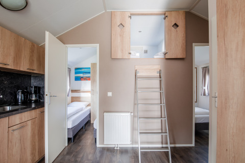 Lodge moderno con altillo abierto, dos dormitorios, cocina y escalera en Vakantiepark Leukermeer, Países Bajos.