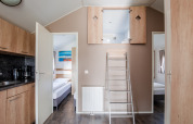 Moderne lodge met open zolder, twee slaapkamers, keuken en ladder bij Vakantiepark Leukermeer, Nederland.