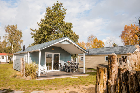 Buitenaanzicht van een Lodge in Vakantiepark Leukermeer in Nederland, omgeven door natuur en bomen.
