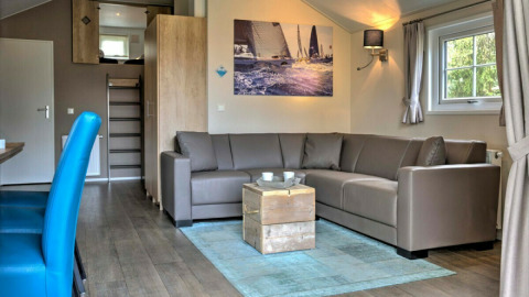 Helle Lodge-Wohnung im Vakantiepark Leukermeer, Niederlande, mit Ecksofa und moderner Einrichtung.