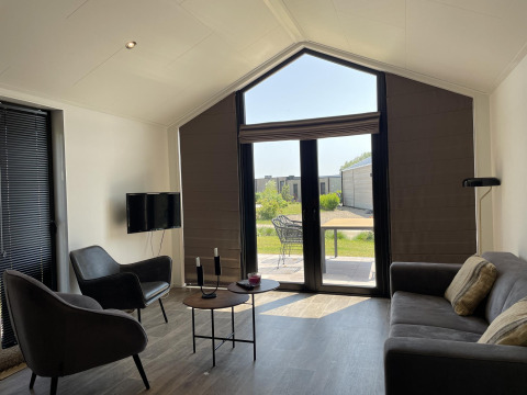 Moderne woonkamer in Beach House Zuid bij EuroParcs Enkhuizer Strand in Nederland, zicht op terras.