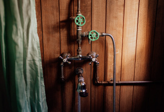 Ducha con viejas válvulas y pared de madera en una cabaña en los árboles, Cosy Cabins, Limburg, Bélgica.