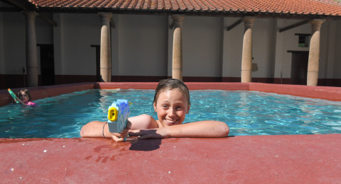 Niño con pistola de agua en la piscina de Lodgetent Archeon Expedition, Expedition Archeon, Países Bajos.