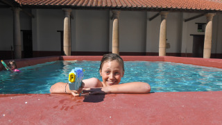 Niño con pistola de agua en la piscina de Lodgetent Archeon Expedition, Expedition Archeon, Países Bajos.