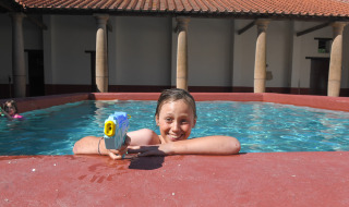 Niño con pistola de agua en la piscina de Lodgetent Archeon Expedition, Expedition Archeon, Países Bajos.