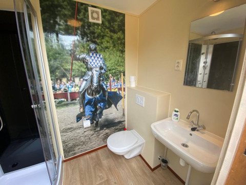 Baño en una tienda safari con un gran mural de un caballero en justa, Lodgetent Archeon Expedition.
