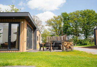 Moderna Oak Lodge con patio e vasca idromassaggio al Vakantiepark Hölte, Paesi Bassi, immersa nel verde.