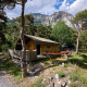 Safari-Zelt Villatent Wood beim Camping River in Frankreich, umgeben von Pinien und Bergen.