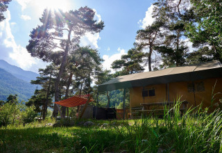 Safaritent Villatent Wood aan Camping River in Frankrijk, omringd door dennen en zonovergoten bergen.