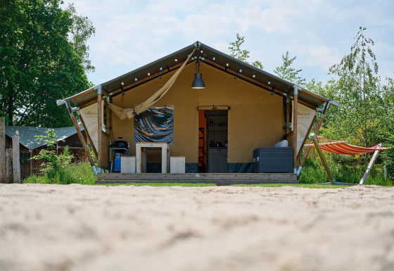 Safaritent Villatent Nomad bij Vakantiepark Sallandshoeve in Nederland met hangmat en uitnodigend terras.