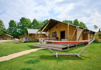 Tente safari Villatent Nomad au Vakantiepark Sallandshoeve, Pays-Bas, avec véranda, hamac et verdure environnante.