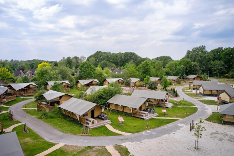 Vista aérea de tiendas safari Villatent Nomad en Vakantiepark Sallandshoeve, rodeadas de naturaleza.
