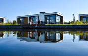 Dos personas se relajan junto al agua en Villa Nautica Deluxe, MarinaPark Residentie Nieuw Loosdrecht, Países Bajos.