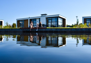 Dos personas se relajan junto al agua en Villa Nautica Deluxe, MarinaPark Residentie Nieuw Loosdrecht, Países Bajos.
