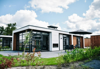 Villa Nautica Deluxe en MarinaPark Nieuw Loosdrecht con diseño moderno, terraza, césped y grandes ventanales.