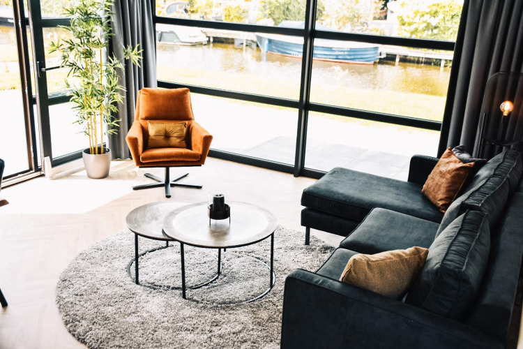 Modern living room at Villa Nautica Deluxe, MarinaPark Residentie Nieuw Loosdrecht, Netherlands, with waterfront view.