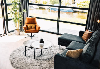 Sala moderna en Villa Nautica Deluxe, MarinaPark Residentie Nieuw Loosdrecht, Países Bajos, vista junto al agua.