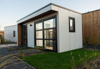 Moderne Villa Nautica Deluxe-lodge med store vinduer og grøn have i MarinaPark Residentie Nieuw Loosdrecht.