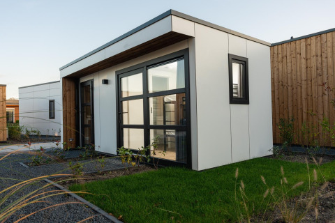 Moderna cabaña Villa Nautica Deluxe con grandes ventanas y césped en MarinaPark Residentie Nieuw Loosdrecht.