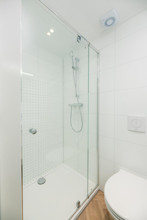 Cabina de ducha moderna con puerta de cristal y ducha de mano en Villa Nautica Deluxe, MarinaPark Residentie Nieuw Loosdrecht.