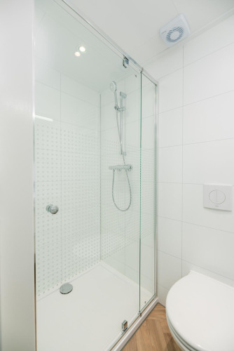 Cabine de douche moderne avec porte en verre et douchette à la Villa Nautica Deluxe, MarinaPark Residentie Nieuw Loosdrecht.