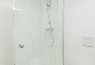 Cabina de ducha moderna con puerta de cristal y ducha de mano en Villa Nautica Deluxe, MarinaPark Residentie Nieuw Loosdrecht.