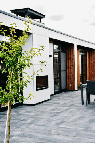Terrasse moderne de la Villa Nautica Deluxe à MarinaPark Residentie Nieuw Loosdrecht, Pays-Bas, avec un arbre.