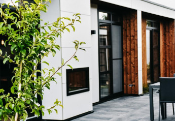 Terraza moderna de la Villa Nautica Deluxe en MarinaPark Residentie Nieuw Loosdrecht, Países Bajos, con vegetación.