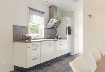 Moderne keuken in een luxe lodge met sauna op Vakantiepark Hölte in Nederland, met witte kasten.