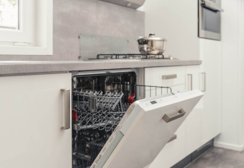Lavastoviglie moderna aperta nella cucina di un lodge di lusso con sauna al Vakantiepark Hölte, Paesi Bassi.