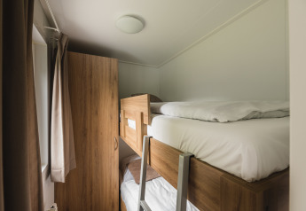 Slaapkamer met stapelbed en kast in de Luxury lodge + sauna van Vakantiepark Hölte, Nederland.