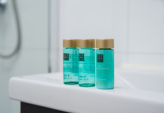 Drie flesjes Rituals bodylotion op een wastafel bij Luxury lodge + sauna, Vakantiepark Hölte, Nederland.
