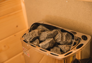 Calentador de sauna con piedras calientes en la Luxury lodge + sauna del Vakantiepark Hölte, Países Bajos.