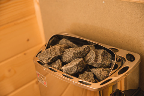 Calentador de sauna con piedras calientes en la Luxury lodge + sauna del Vakantiepark Hölte, Países Bajos.