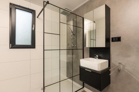 Bagno moderno con doccia in vetro e arredamento bianco e nero a Oak Lodge, Vakantiepark Hölte, Paesi Bassi.