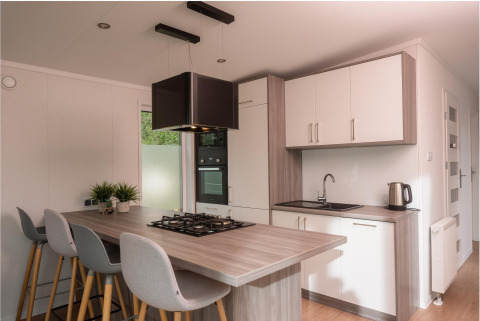 Modernes kleines Kücheninterieur mit Kochinsel und Essbereich in einer Tiny Cabin im Vakantiepark Hölte, Niederlande.